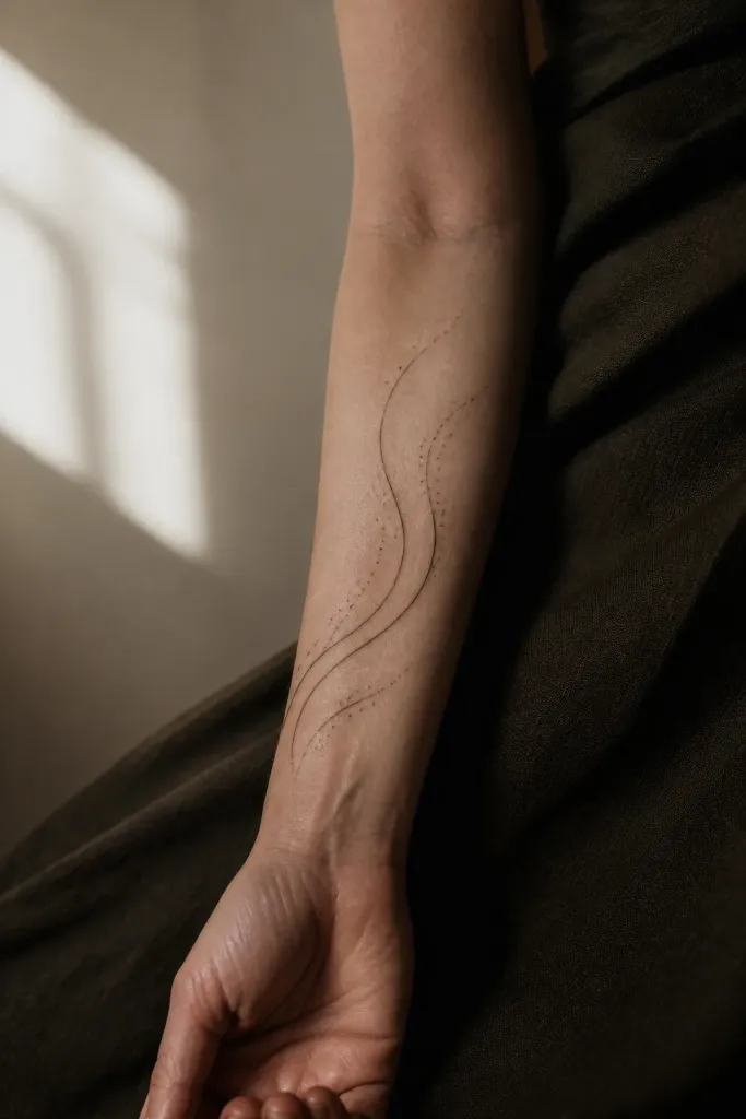 Tatouage abstrait composé de lignes fluides sur un avant-bras